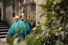 a woman in a blue dress standing on some steps