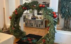 a living room decorated for christmas with wreaths and ornaments