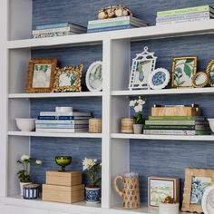 a book shelf filled with lots of books and vases on top of it's shelves