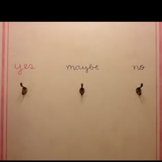 two hooks are attached to the wall with words written on them