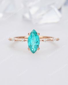 an oval cut blue topazte and diamond ring in rose gold with two side stones