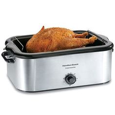 a roasting chicken in a slow cooker with the lid open to show it's skin