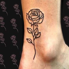 a small rose tattoo on the side of a woman's lower back ribcage