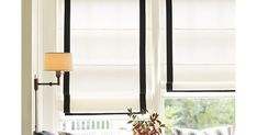 a living room filled with furniture and a lamp next to a window covered in blinds