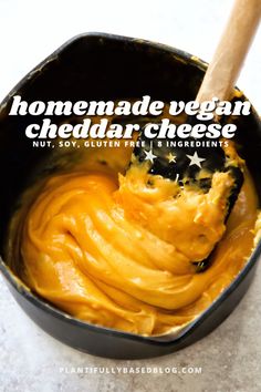 homemade vegan cheddar cheese in a black pan with a wooden spoon inside