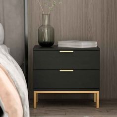 a black and gold nightstand next to a bed with a vase filled with flowers on it