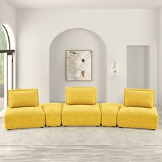 a living room with white walls and yellow couches in the middle of the room