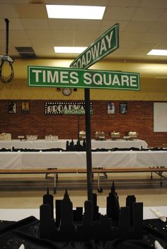 there is a street sign that says broadway and times square in front of tables with white tablecloths