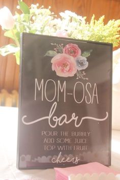 a sign that says mom - osa bar with flowers in the background and soaps next to it