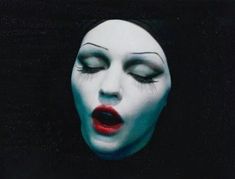 a woman with white makeup and red lips