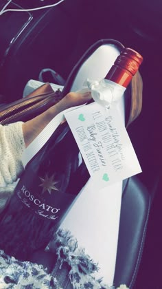 a bottle of wine sitting in the back seat of a car next to a note