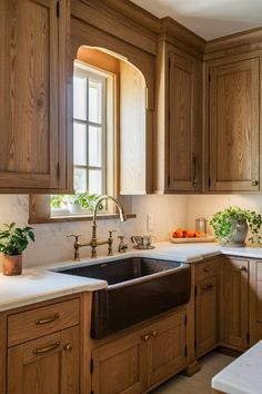 a kitchen with wooden cabinets and white counter tops, along with a large window over the sink