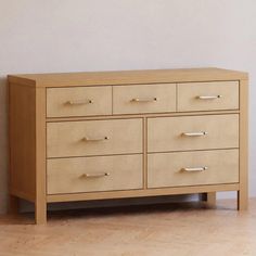 a wooden dresser sitting on top of a hard wood floor next to a white wall