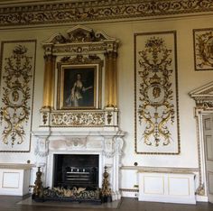 an ornately decorated room with a fireplace and paintings hanging on the wall above it