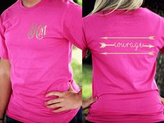 a woman wearing a pink shirt with an arrow on the front and monogrammed lettering on the back