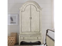 an antique white armoire in a bedroom