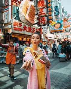 a woman dressed in traditional chinese clothing holding food