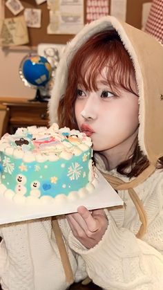 a woman holding a cake in front of her face