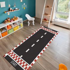 a child's playroom with toys and bookshelves on the floor in front of a blue wall