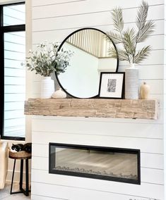 a living room with a fireplace and mirror on the mantle