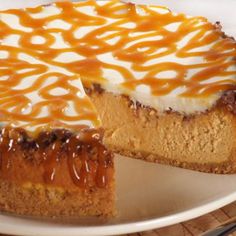 a cheesecake topped with caramel sauce and drizzled in icing