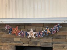 an american flag garland hanging from a fireplace mantle with the word usa spelled in stars