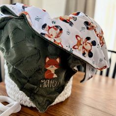 a hat with a fox on it sitting on top of a wooden table