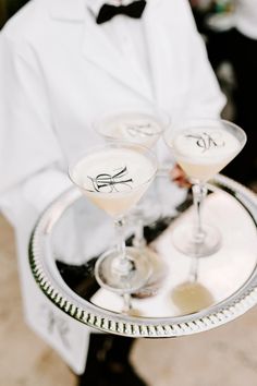 two martini glasses sitting on top of a silver tray