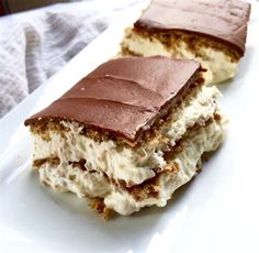 two pieces of cake sitting on top of a white plate with frosting and chocolate