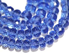 blue glass beads are shown on a white surface