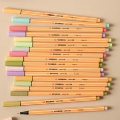 several different colored pencils lined up next to each other with erasers on them