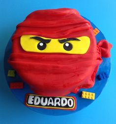 there is a cake made to look like the face of a lego ninja on top of a blue plate