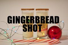 two glasses filled with gingerbread shot next to candy canes and christmas lights on a white background