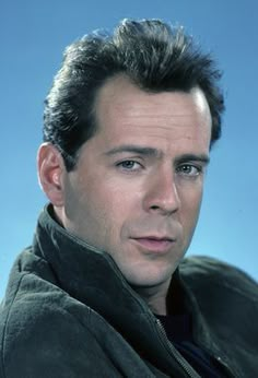 a close up of a person wearing a jacket and looking at the camera with a serious look on his face