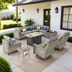 an outdoor living area with grey wicker furniture and yellow pillows on the couches