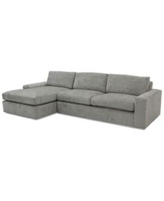 a gray sectional couch sitting on top of a white floor