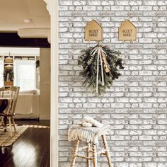 a white brick wall with two wreaths hanging on it's sides and a sign that says sweet home