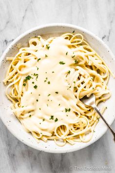 a white bowl filled with pasta and sauce