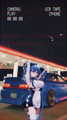 a woman standing next to a blue car in front of a gas station at night