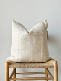 a white pillow sitting on top of a wooden chair