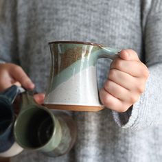 a person holding a coffee mug in their hands