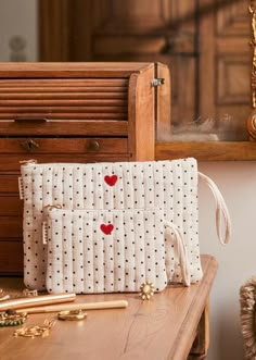 a purse sitting on top of a wooden table next to a mirror and other items