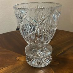 a glass vase sitting on top of a wooden table