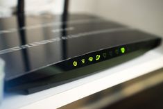 a close up view of a router with green lights on the front and back