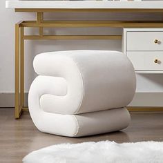 a white chair sitting on top of a wooden floor in front of a desk with a mirror