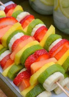 fruit skewers are arranged on a white plate