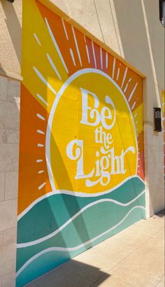 a large sign on the side of a building that says be the light