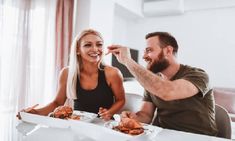 a man and woman sitting at a table eating food