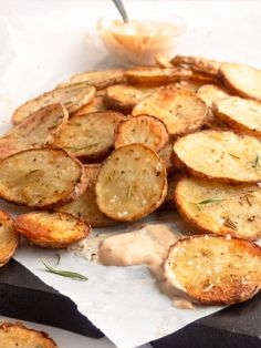 baked potato wedges with sauce and herbs on the side, ready to be eaten