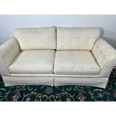 a white couch sitting on top of a rug